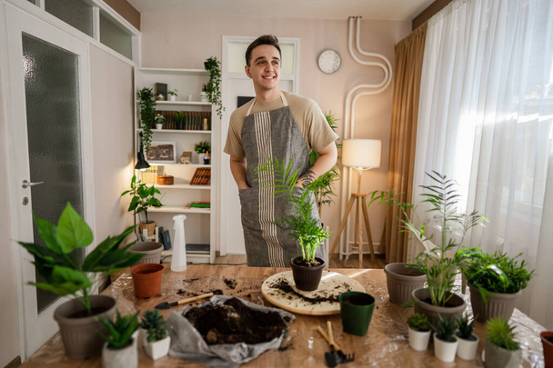 Un hombre adulto caucásico jardinero masculino o florista cuidar y cultivar plantas de flores domésticas en el hogar concepto de jardinería espacio de copia - Foto, Imagen