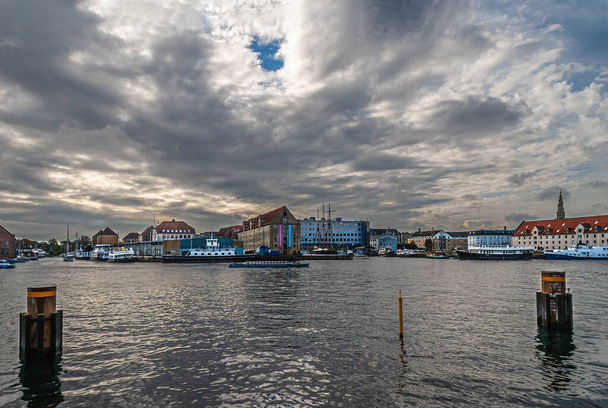 Kopenhagen, Dänemark - 13. September 2010: Östlich von Nyhavn über das Chistianshavn-Wasser auf einem weiten Panorama von Wohn- und Bürogebäuden, Boote, die unter schweren grauen Wolken andocken - Foto, Bild