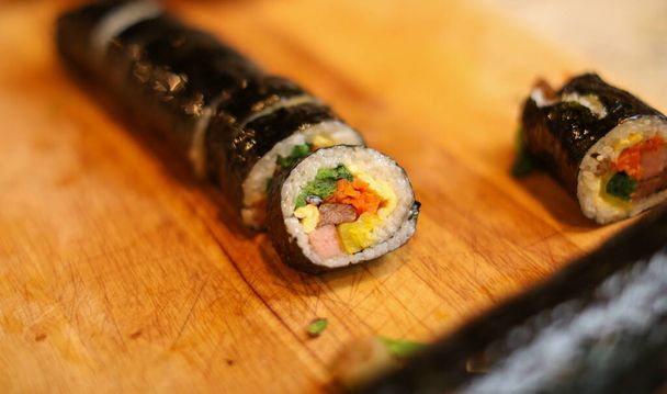 sushi roll with salmon, avocado, cucumber and sesame. - 写真・画像