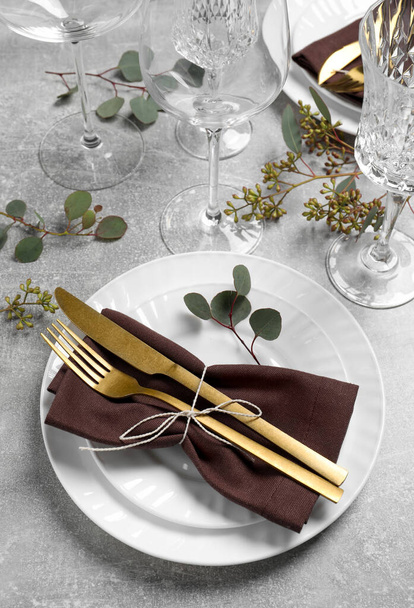 Stilvolle Tischdekoration mit Besteck und Eukalyptusblättern, oben Ansicht - Foto, Bild