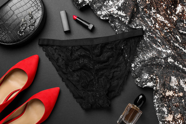 Flat lay composition with black women's underwear on dark grey background - 写真・画像
