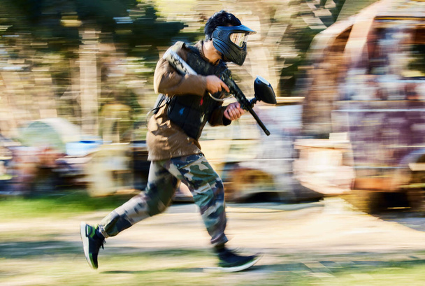 Fast, running and paintball man, gun and outdoor battlefield, playground or games in forest adventure training. Shooting skill, player or sports person with military speed, action and target mission. - Photo, Image