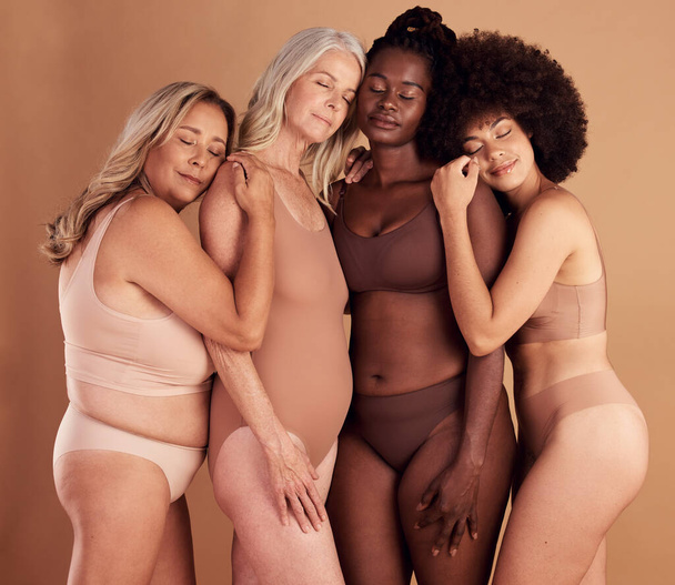 Plus size women, model group and lingerie in studio for support, solidarity and diversity with comfort. Body positive, multicultural woman and underwear with hug, love and together by studio backdrop. - Foto, Bild