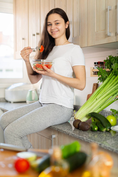Healthy lifestyle smiling woman eating vegetable salad at home kitchen - Foto, Bild