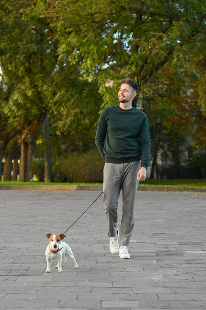 Man with adorable Jack Russell Terrier on city street. Dog walking - Foto, Imagen