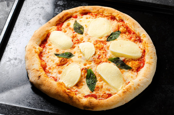 Pizza Margherita italienne congelée avec mozzarella sur fond foncé - Photo, image