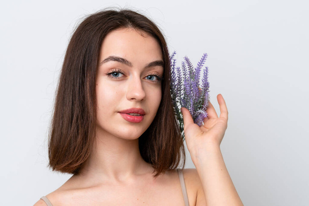 Junge Ukrainerin isoliert auf weißem Hintergrund mit einer Lavendelpflanze. Porträt aus nächster Nähe - Foto, Bild