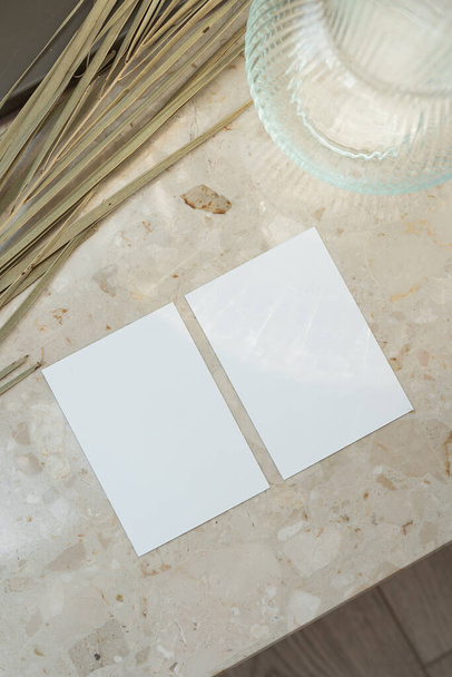 Hoja de papel con espacio de copia sobre fondo de mármol con hoja de palma y jarrón - Foto, imagen