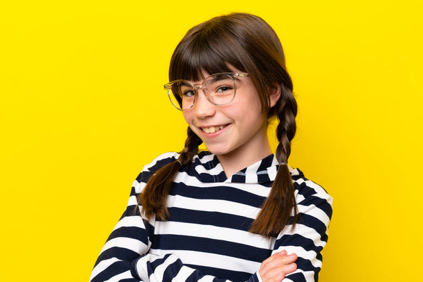 Little caucasian girl isolated on yellow background With glasses with happy expression - Foto, imagen