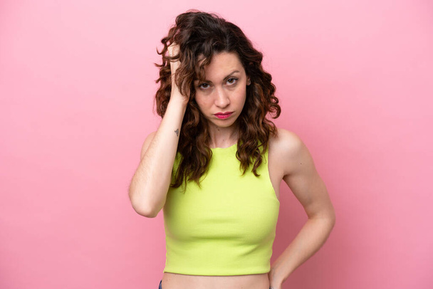 Young caucasian woman isolated on pink background with an expression of frustration and not understanding - Photo, Image