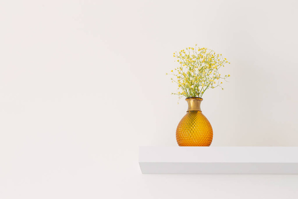 yellow gypsophila in glass vase in white room - 写真・画像