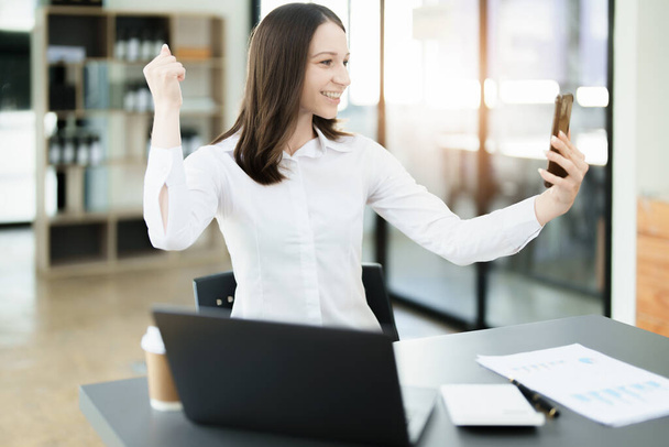 Excited businesswoman using mobile phone while in office , business concepts - Photo, Image