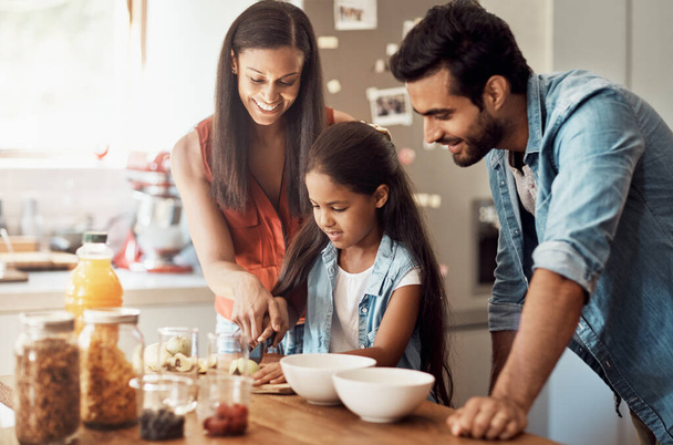 Bıçağa dikkat et. Genç ve mutlu bir aile, mutfakta birlikte yemek hazırlıyor. - Fotoğraf, Görsel