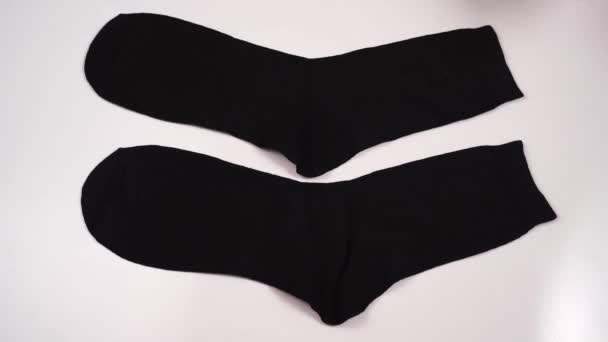 Deux chaussettes noires. Les hommes plient les sous-vêtements après le lavage. Images 4k de haute qualité - Séquence, vidéo