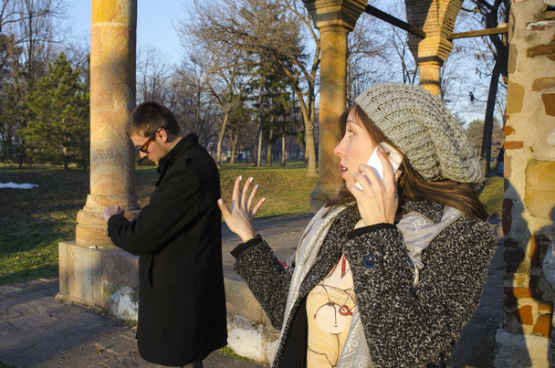 Girl talking on the phone while her boyfriend waits - Valokuva, kuva