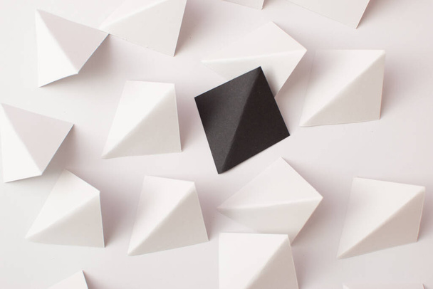 Witte en zwarte driehoekige vormen op witte achtergrond. Denk buiten het kader concept - Foto, afbeelding