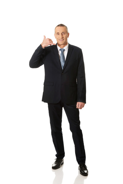 Businessman with call me gesture - Photo, Image