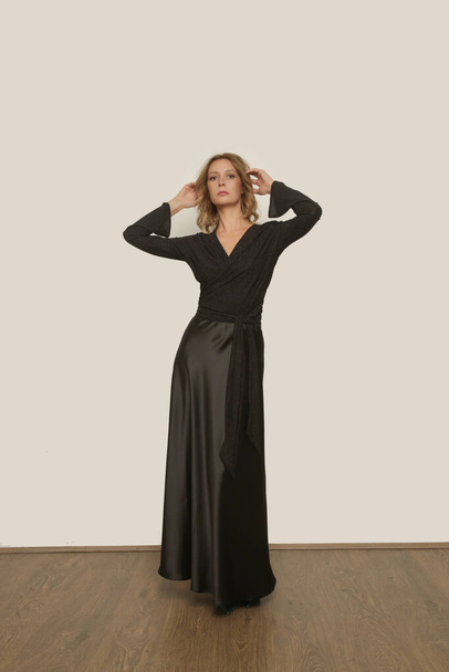 Serie de fotos de estudio de la joven modelo femenina con maxi falda de seda negro con blusa envuelta en negro - Foto, imagen
