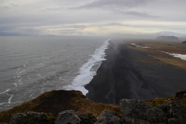 Blick auf endlosen Ozean schwarzen vulkanischen Sandstrand vom Dyrholaey Cape Viewpoint, Vik, Süd-Island. - Foto, Bild