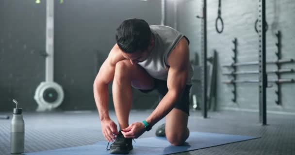 Fitness, exercise and gym man prepare shoes for training, cardio exercise or workout. Footwear, start or healthy athlete ties shoe lace getting ready for exercising for training, health and wellness. - Footage, Video