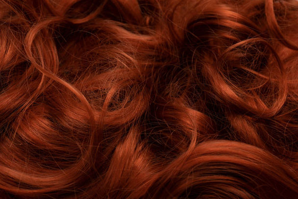 Red hair as a background. Curly red hair.  - 写真・画像