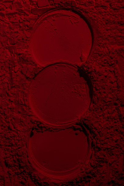 Red texture. Powder background. Pedra, sand. Red color. Dark red. Intense dark red. Cracks, waves, lines, circles, depressions. convex. Banner, advertising, for inscription - Photo, Image
