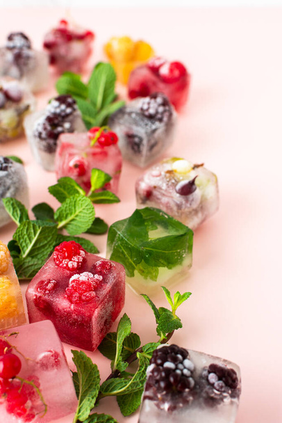 Frozen ice cubes with various berries, blackberries and raspberries, gooseberries and currants, blueberries and mint - Fotoğraf, Görsel