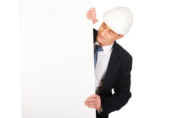 Businessman with hard hat holding empty banner - Foto, immagini