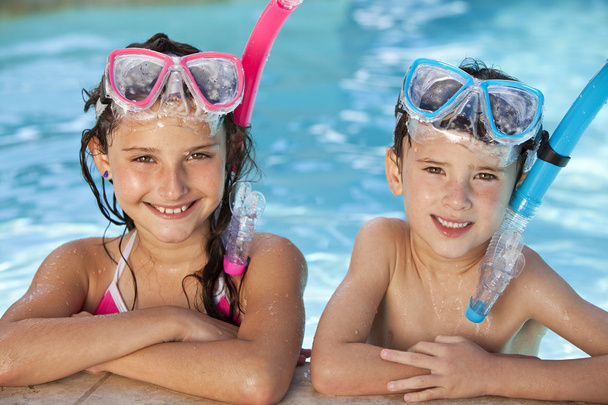 Niño y niña en la piscina con gafas y snorkel
 - Foto, imagen