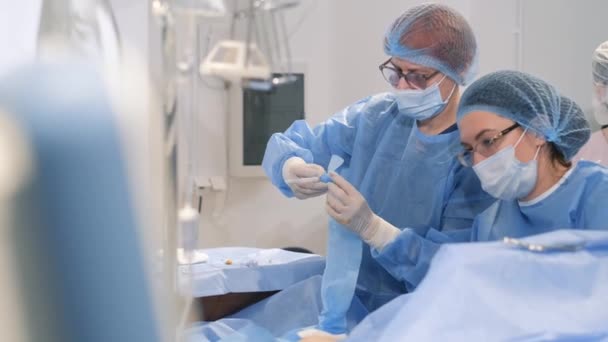 A female surgeon performs a caesarean section. A doctor in protective clothing with an assistant performs an operation using sterilized equipment. - Footage, Video