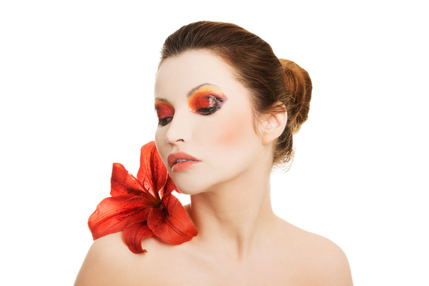 Portrait of young woman with red lily flower - Zdjęcie, obraz