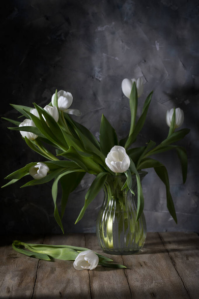 White tulips in a glass vase on a wooden table - Foto, Imagen