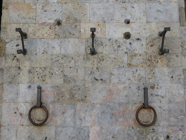 anéis de cavalo em uma parede de pedra para a amarração de cavalos do século XV circa
 - Foto, Imagem