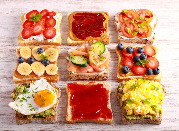 Wybór toastów śniadaniowych z różnymi dodatkami - słonych i słodkich. Kanapka, tosty mix, śniadanie lub brunch, koncepcja - Zdjęcie, obraz