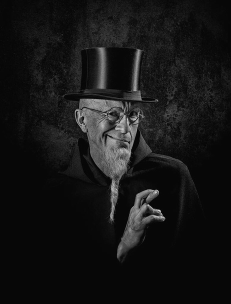 黒の高い帽子と黒の衣を着た謎の男性魔術師の肖像. - 写真・画像