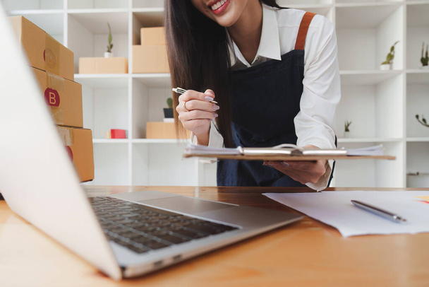 Kisvállalkozások KKV tulajdonosok női vállalkozók ellenőrizze az online megrendelések, hogy felkészüljenek a dobozok, eladni az ügyfeleknek, sme üzleti ötletek online. - Fotó, kép