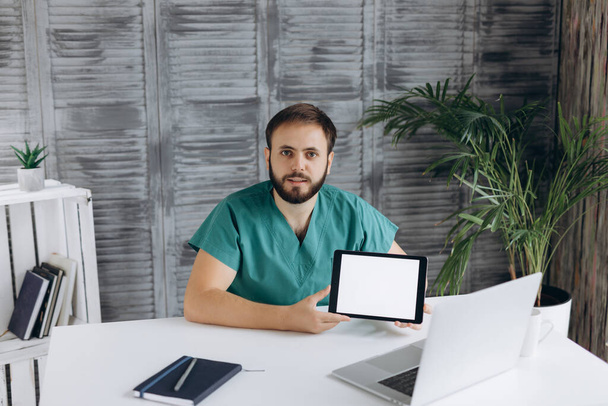Кавказский врач демонстрирует навыки уверенности на рабочем месте клиники. - Фото, изображение