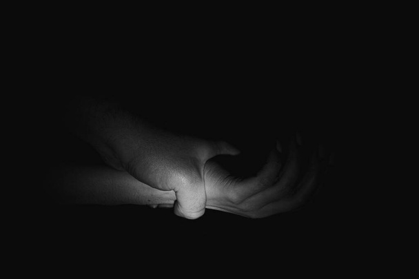 男性の手は床の上の暗闇の中で女性の手を保持します,女性に対する暴力 - 写真・画像