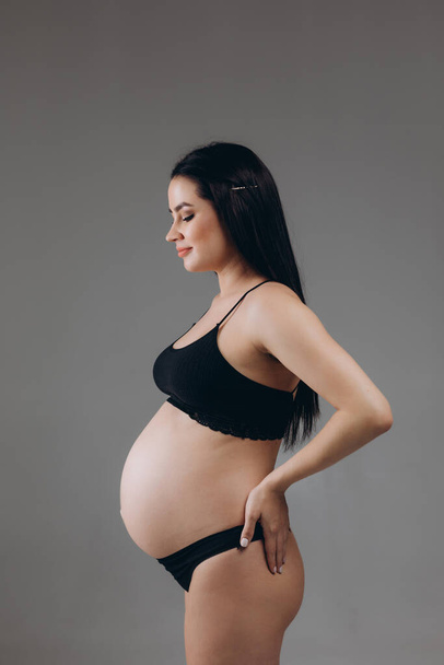 Donna incinta che si tocca la pancia. Chiudete. Concetto di maternità, gravidanza e attesa. - Foto, immagini