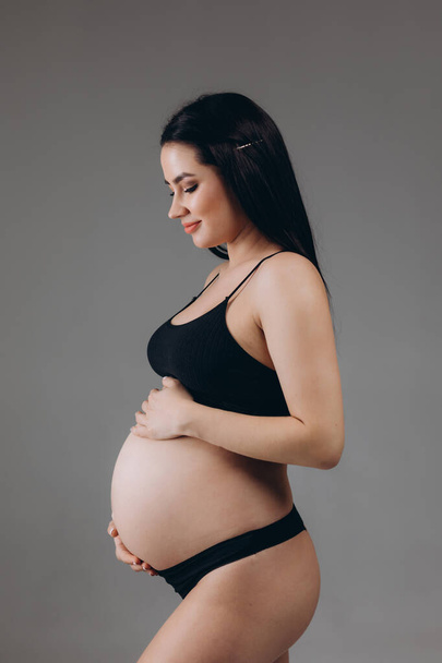 Femme enceinte touchant son gros ventre. Ferme là. Concept de maternité, de grossesse et d'attente. - Photo, image