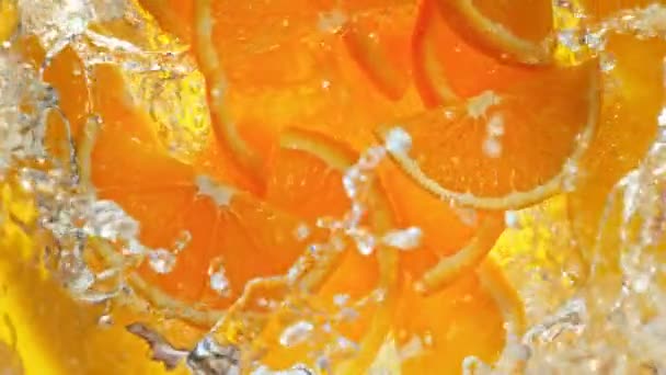 Super Slow Motion Shot de rodajas de naranja fresca cayendo en el remolino de agua a 1000 fps. Filmado con cámara de cine de alta velocidad en 4k. - Metraje, vídeo