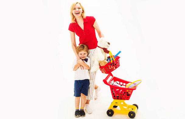Happy family mother and son with shopping basket and shopping cart with sport equipment on shop. Mother with son on shopping. Sale. Discount. Black friday. Buying spree. Advertising - Photo, Image