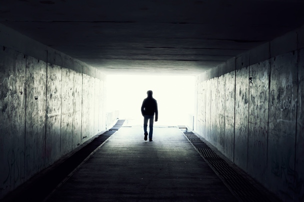 Silhouette dell'uomo che cammina nel tunnel. Luce alla fine del tunnel
 - Foto, immagini