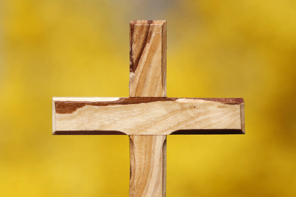 Keresztény kereszt a sárga seprűvirág ellen. Vallási szimbólum. - Fotó, kép