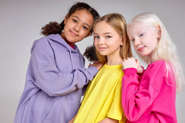 young beautiful multiethnic girls has deep warm relationships among each other. close up portrait, isolated white backjground. joyful kids look at camera.Best Friends Forever - Photo, Image