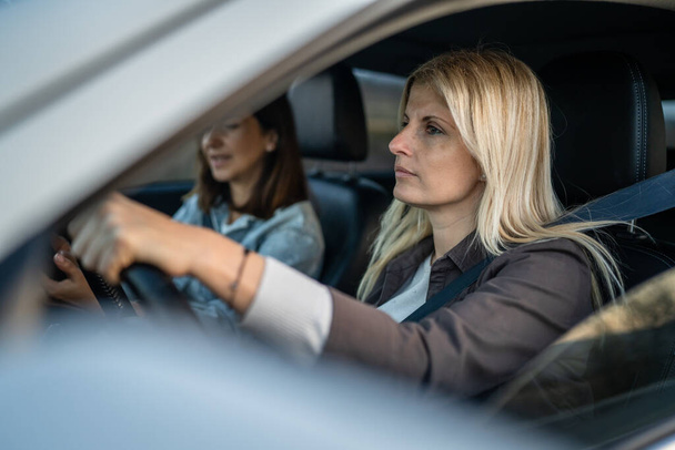 two women drive in a car travel mature caucasian female friends on the road in automobile real people copy space - Photo, Image
