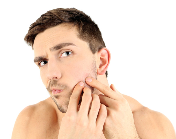 young man squeezing pimple - 写真・画像