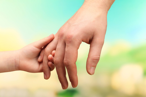 Child and father hands on bright background - Photo, Image