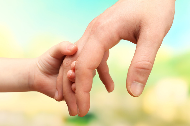 Child and father hands on bright background - Foto, Imagen