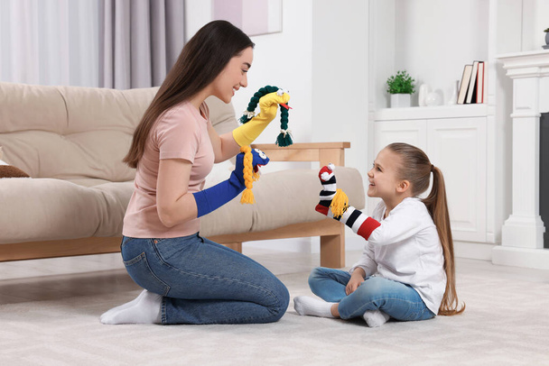 Happy mother and daughter playing with funny sock puppets together at home - Fotoğraf, Görsel